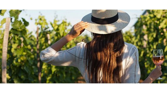 Woman in a vineyard holding a glass of wine 