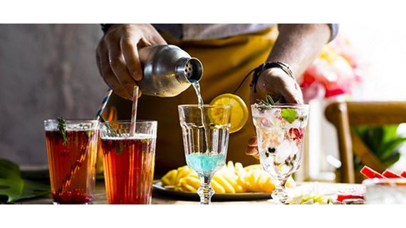 Close up of bartender pouring a drink into a glass