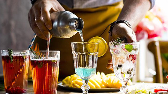 Close up of bartender pouring a drink into a glass