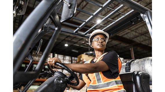 Man driving forklift in distribution center