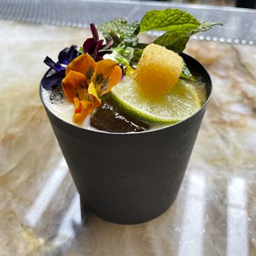 A a creative Toca Madra cocktail, topped with vibrant and edible garnishes.