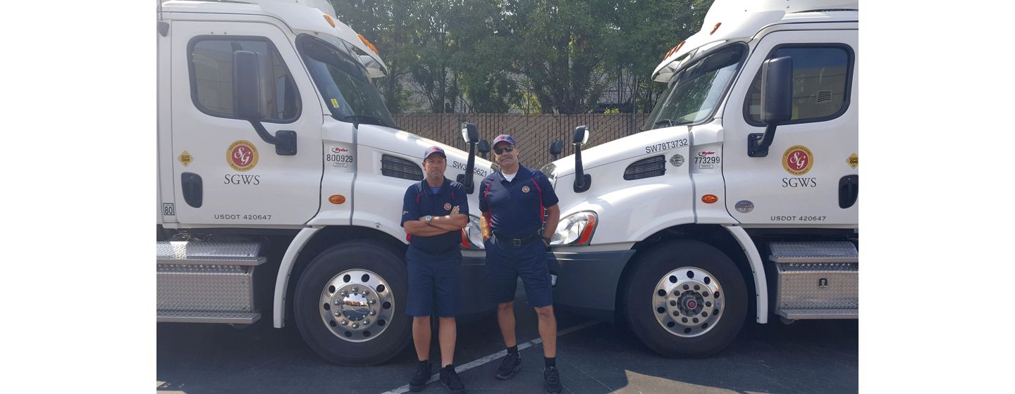 Two drivers standing in front of trucks
