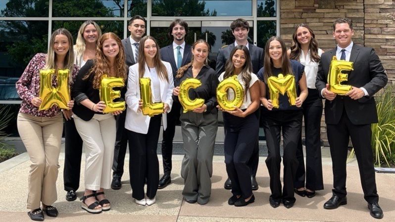 Interns holding baloons that spell welcome