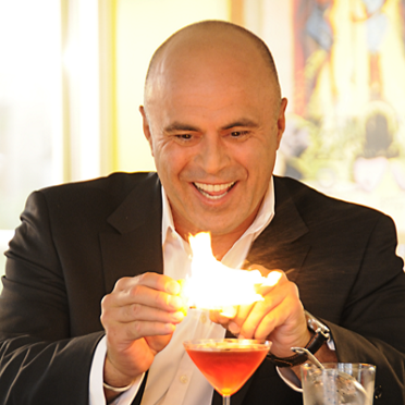 Mixologist Tony Abou-Ganim igniteing a cocktail.