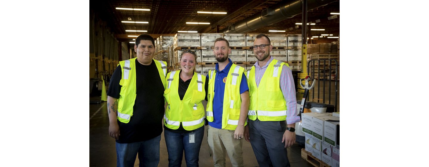 Four distribution center employees standing together