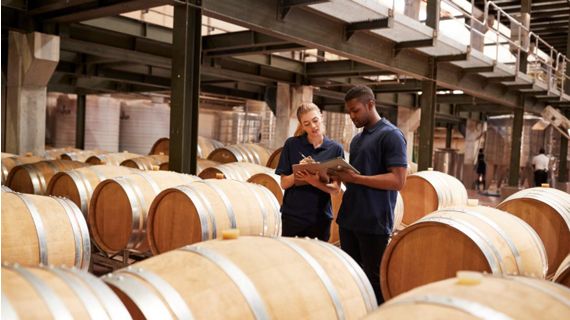 woman and man in warehouse with barrels