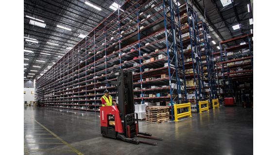 Man driving forklift in distribution center