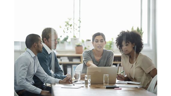 Diverse group gathered around laptop