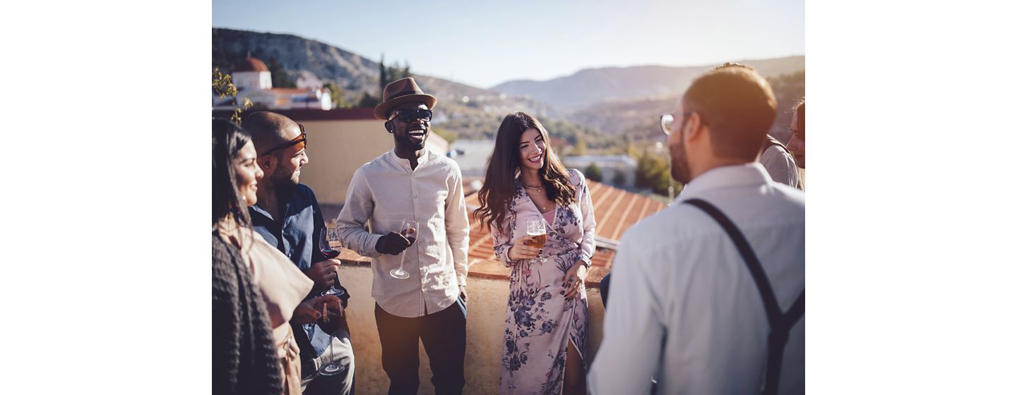 Young elegant multi-ethnic friends and couples relaxing at wine and beer tasting at French village