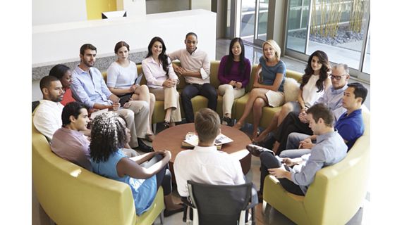 Corporate employees circled around table