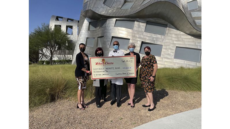 Diverse group holding large check