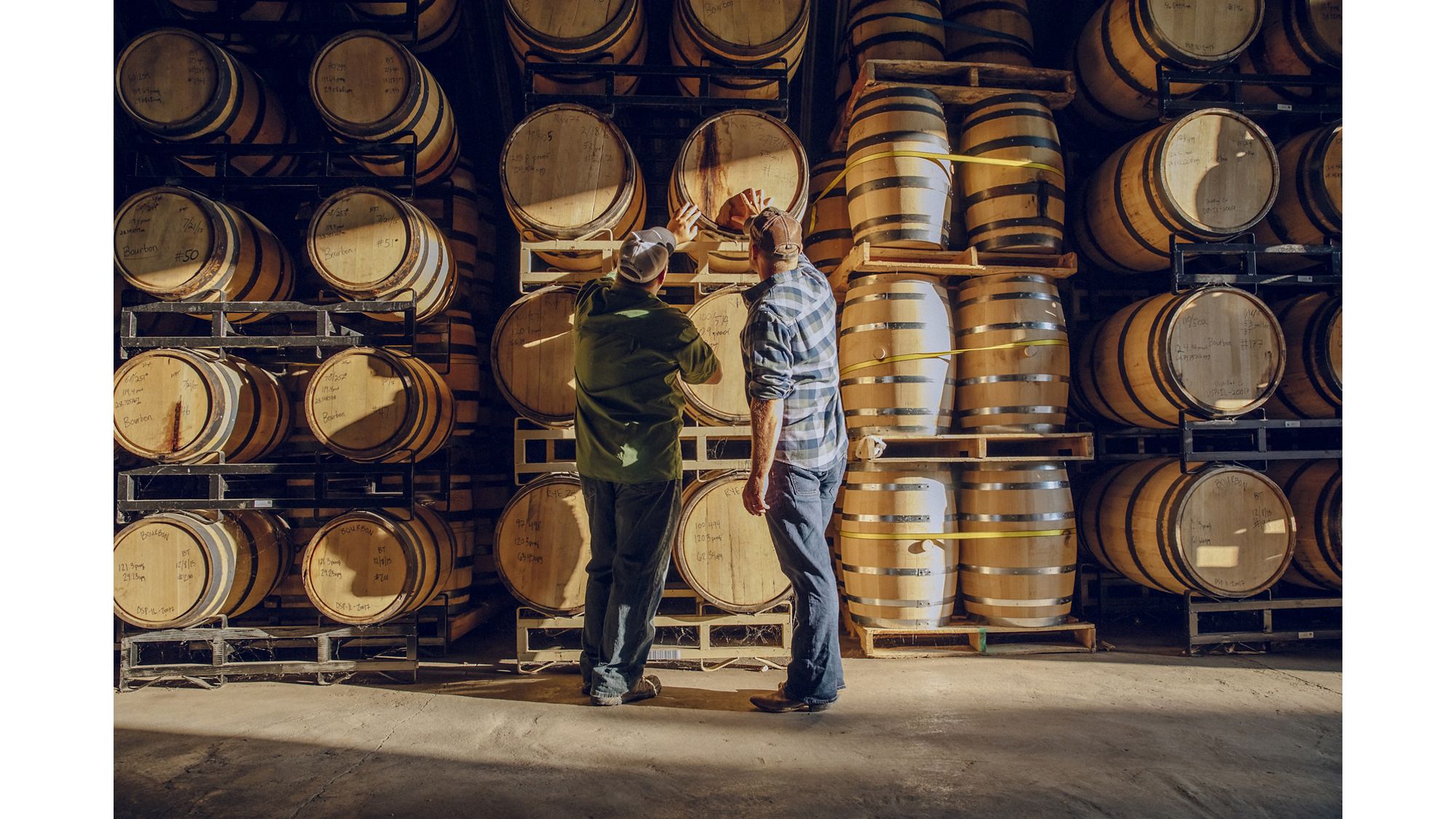 Two men looking through beverage barrel inventory