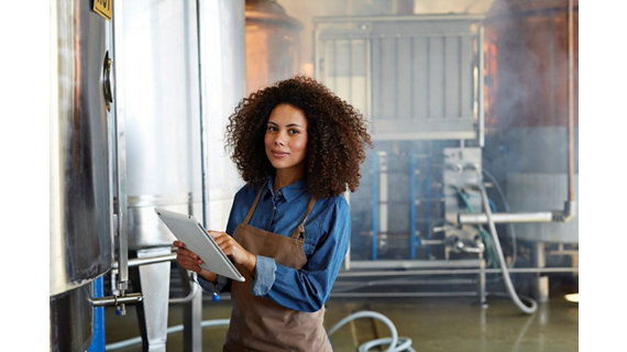 Woman in distillery working on tablet 