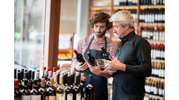 Two men looking at wine bottles