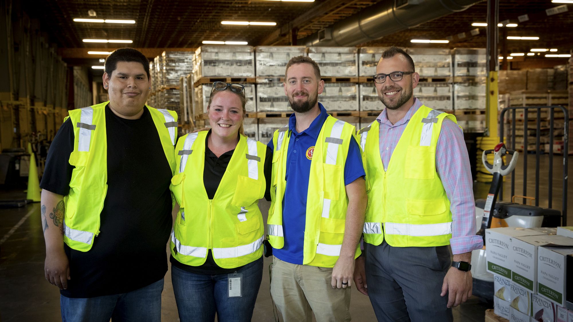 Four distribution center workers standing together