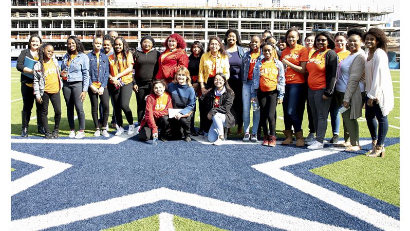 Group of students on Dallas Cowboys football field.