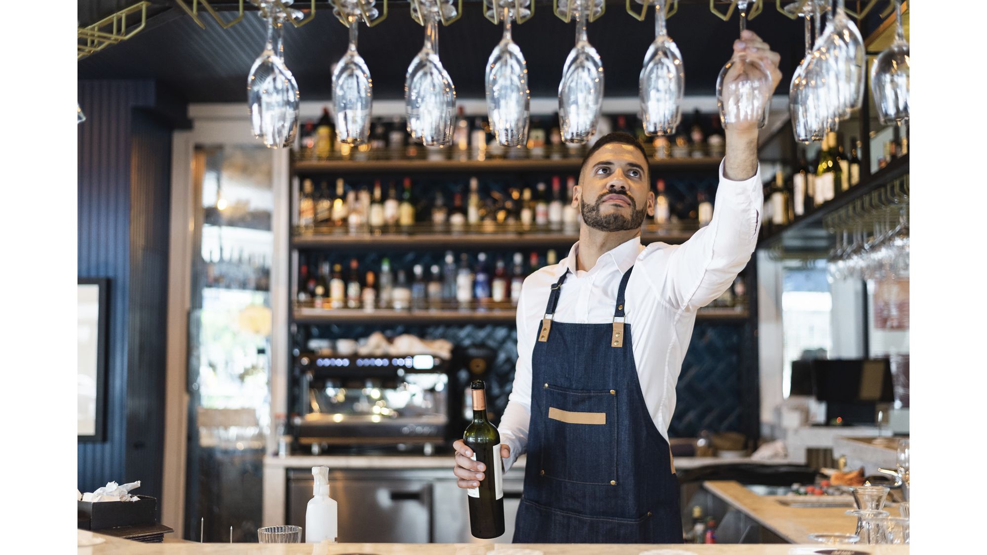 Bartender picking up a glass of wine